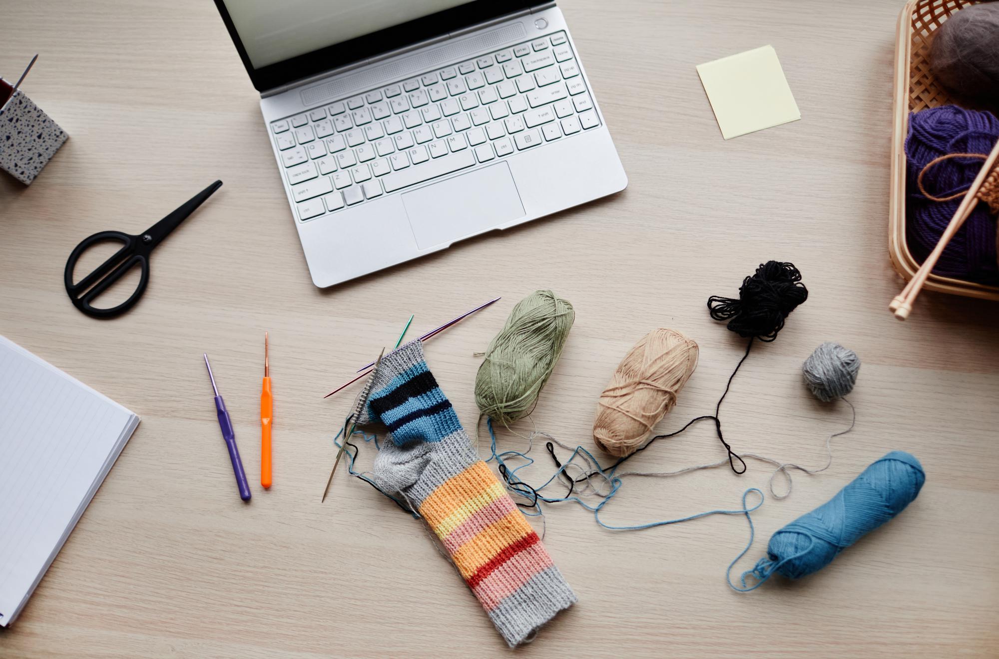 Workshop table with hoop and threads beside a laptop